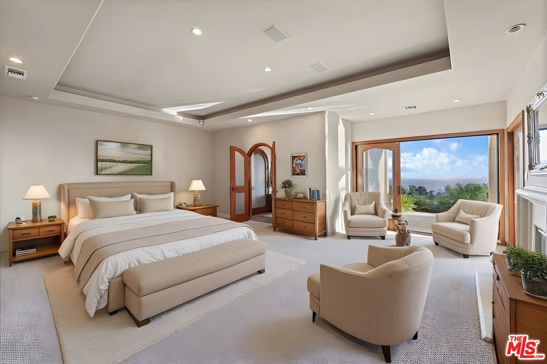 1740 Carla Ridge Beverly Hills, CA 90210 - Photo 25 of 36 a spacious bedroom with a large bed and a large window