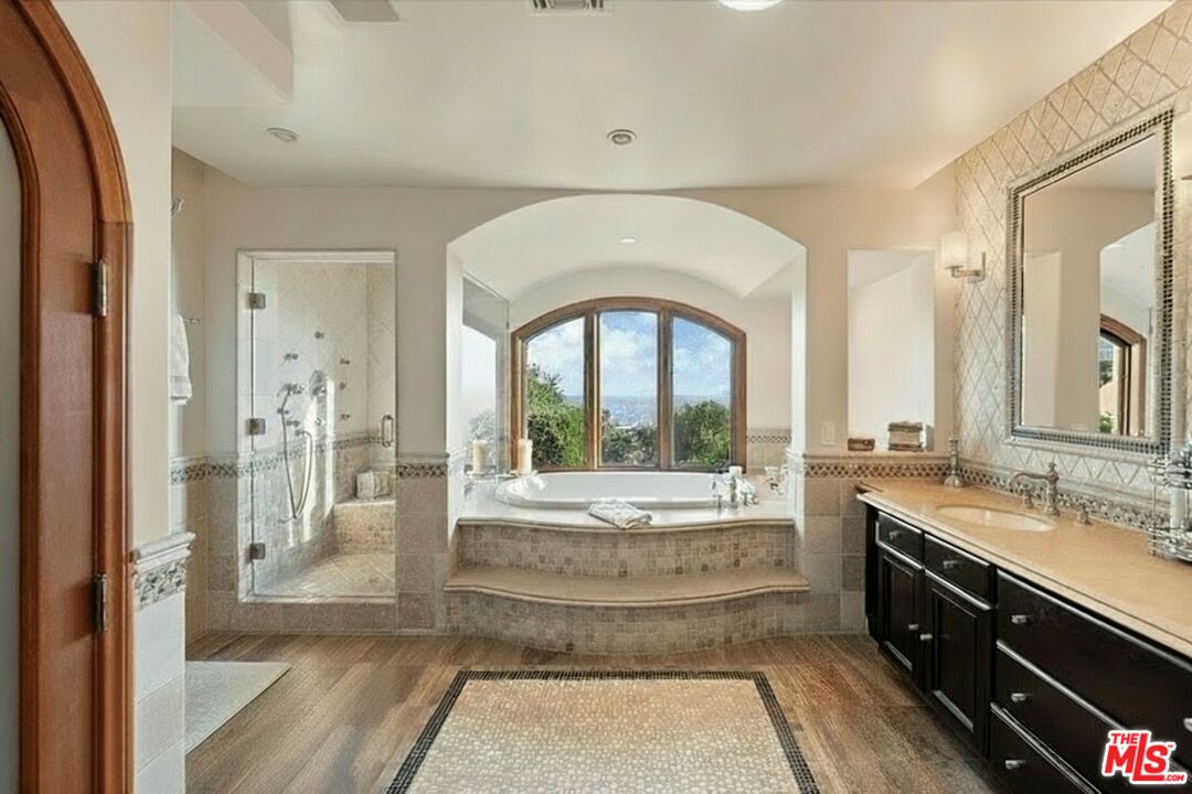 1740 Carla Ridge Beverly Hills, CA 90210 - Photo 27 of 36 a spacious bathroom with a double vanity sink and a large mirror
