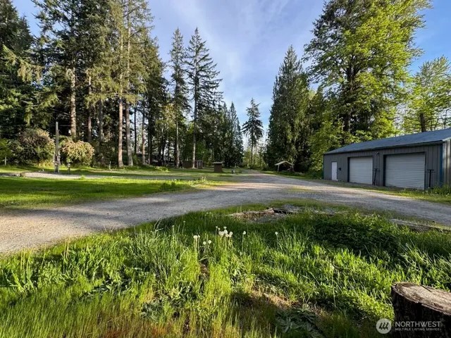 a backyard of a house with lots of green space and fountain