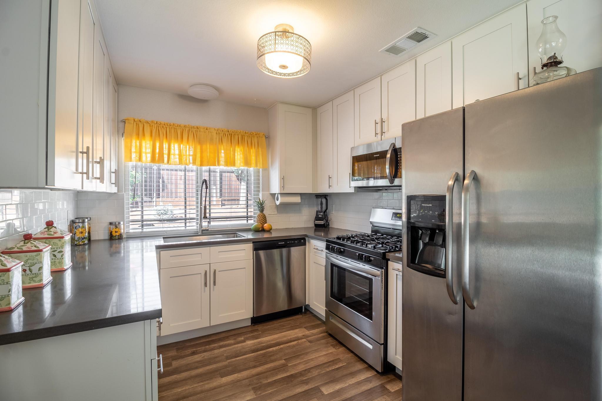 6875 Crest Avenue Riverside, CA 92503 - Photo 8 of 31 a kitchen with stainless steel appliances granite countertop a sink a stove a refrigerator cabinets and a window