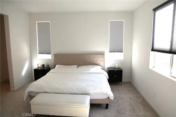 a view of a bedroom with a bed and a window