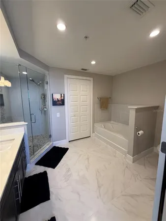 a bedroom with a large bed and windows