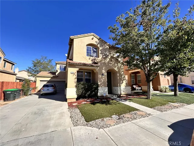 a view of a white house with a large tree