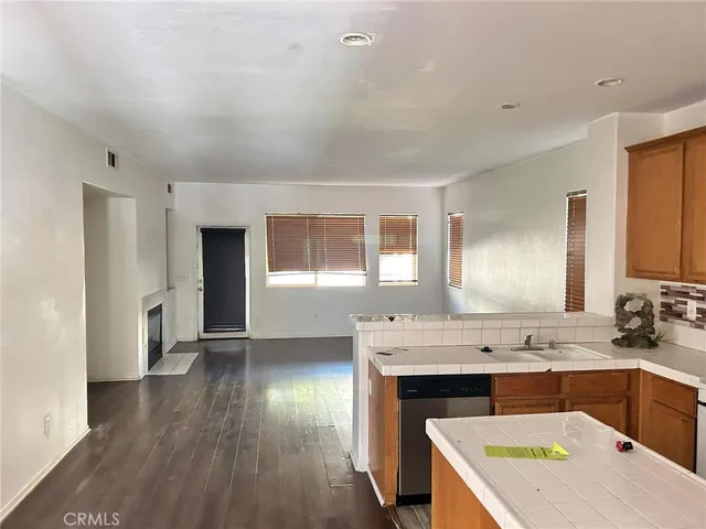a kitchen with granite countertop a stove a sink and a refrigerator