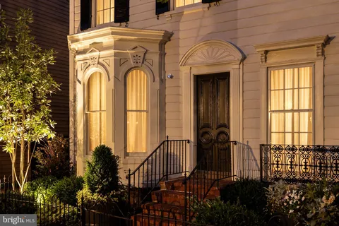 a view of a brick house with many windows and potted plants