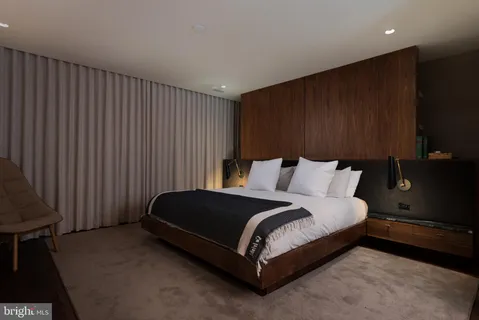 a spacious bedroom with a bed and a dresser