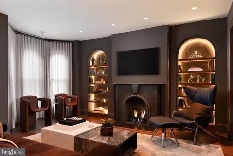 a living room with furniture a fireplace and a flat screen tv