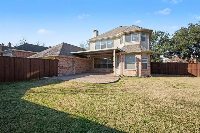 a view of a house with a yard and wooden fence