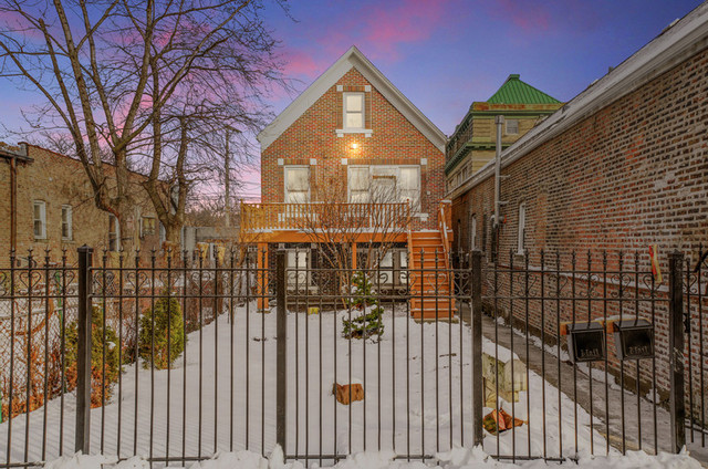 a view of a brick house with iron fence