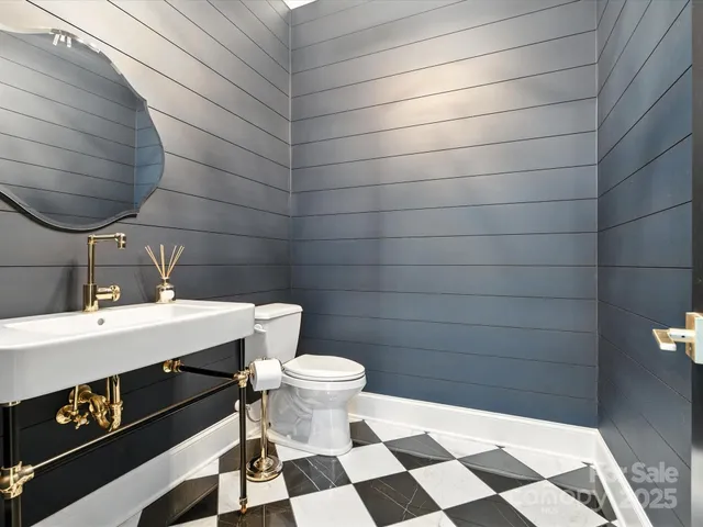 a bathroom with a sink a toilet and a mirror