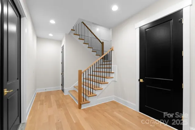 a view of a hallway with wooden floor and staircase