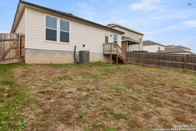 a view of a house with backyard and a tree