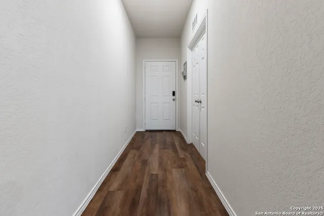 a view of a hallway with wooden floor