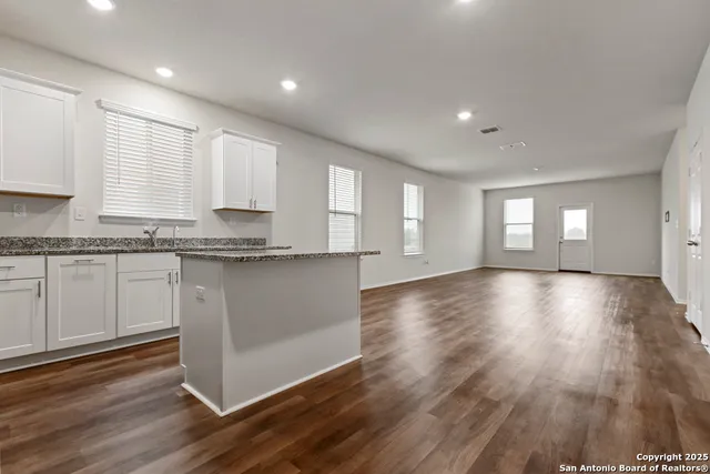 a view of a kitchen with wooden floor and a window