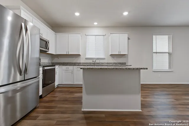 a kitchen with granite countertop stainless steel appliances and wooden cabinets