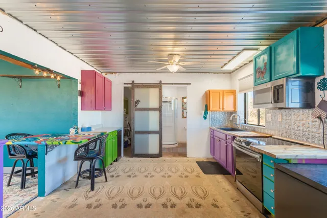 a kitchen that has a lot of cabinets a sink and appliances