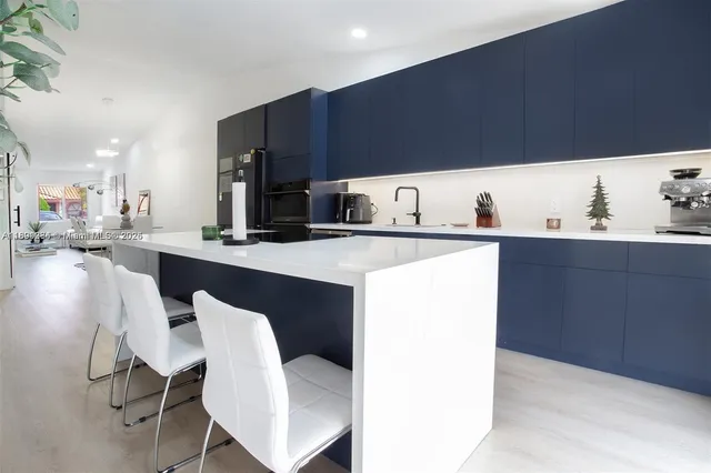 a kitchen with a sink cabinets and wooden floor