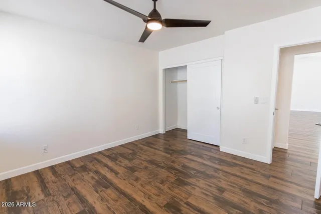 a view of empty room with wooden floor