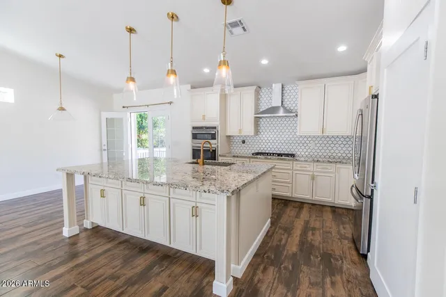 a kitchen with white cabinets appliances and a wooden floor