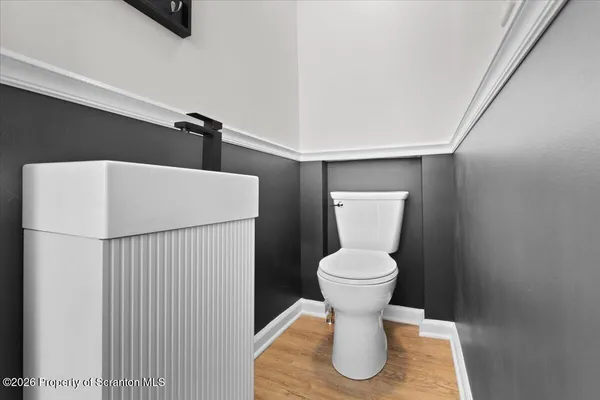 a white toilet sitting next to a white cabinet