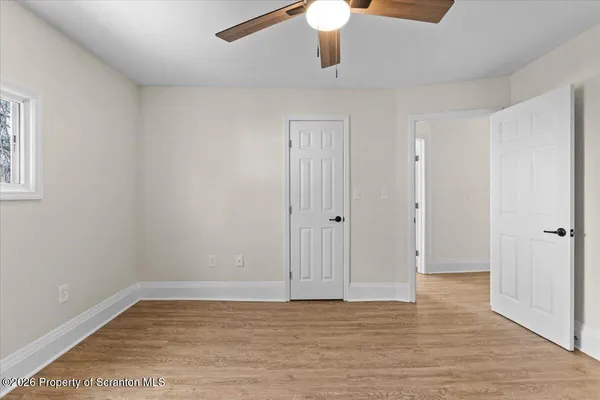 a view of an empty room with wooden floor