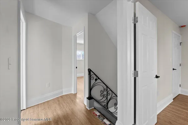 a view of a hallway with wooden floor and stairs