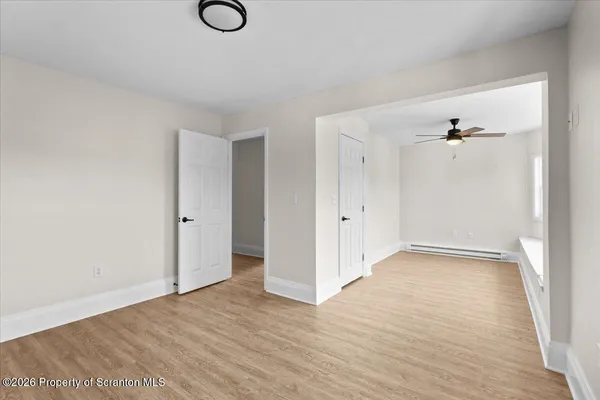 a view of an empty room with wooden floor