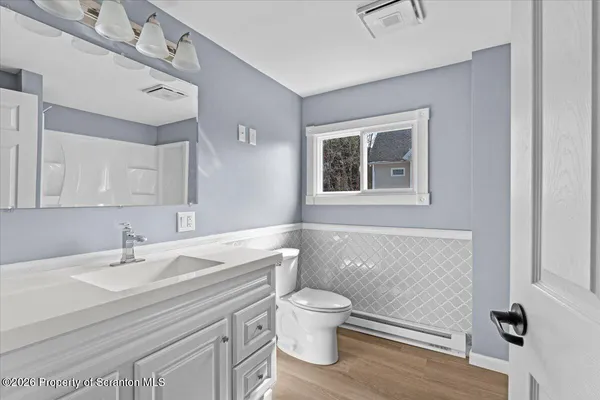a bathroom with a sink a toilet and a mirror