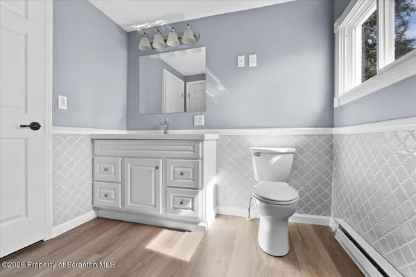 a bathroom with a granite countertop toilet a sink and a mirror