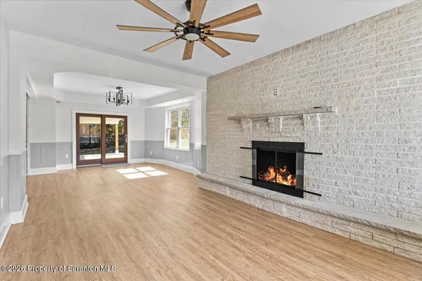 a view of an empty room with a fireplace and a window