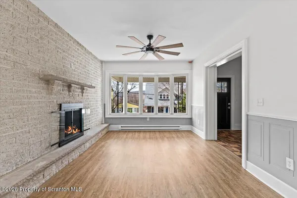 wooden floor fireplace and windows in an empty room