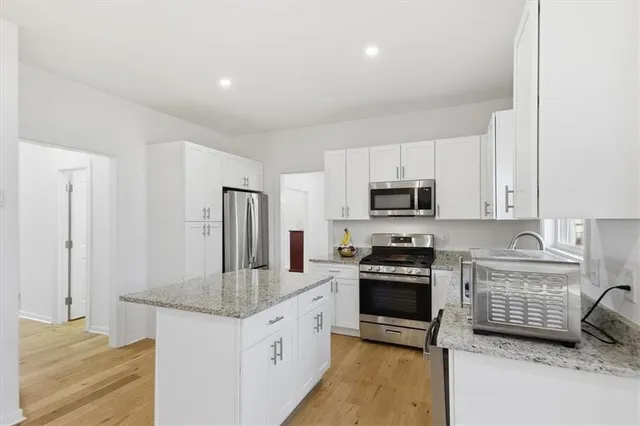 a kitchen with granite countertop a refrigerator stove and sink