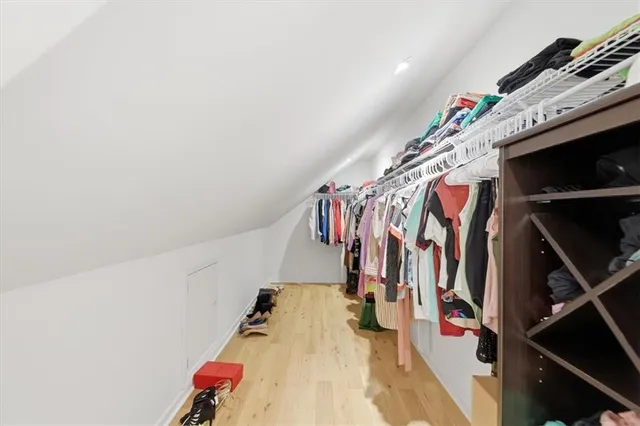 a view of walk in closet with clothes and shoes