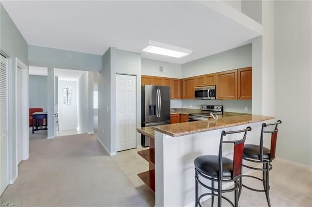 a kitchen that has a lot of cabinets a sink and a refrigerator