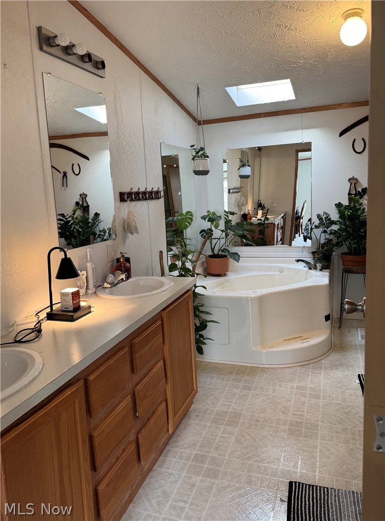 28240 Osborne Road Coolville, OH 45723 - Photo 18 of 29 Full bathroom featuring a skylight, double vanity, a bath, and crown molding