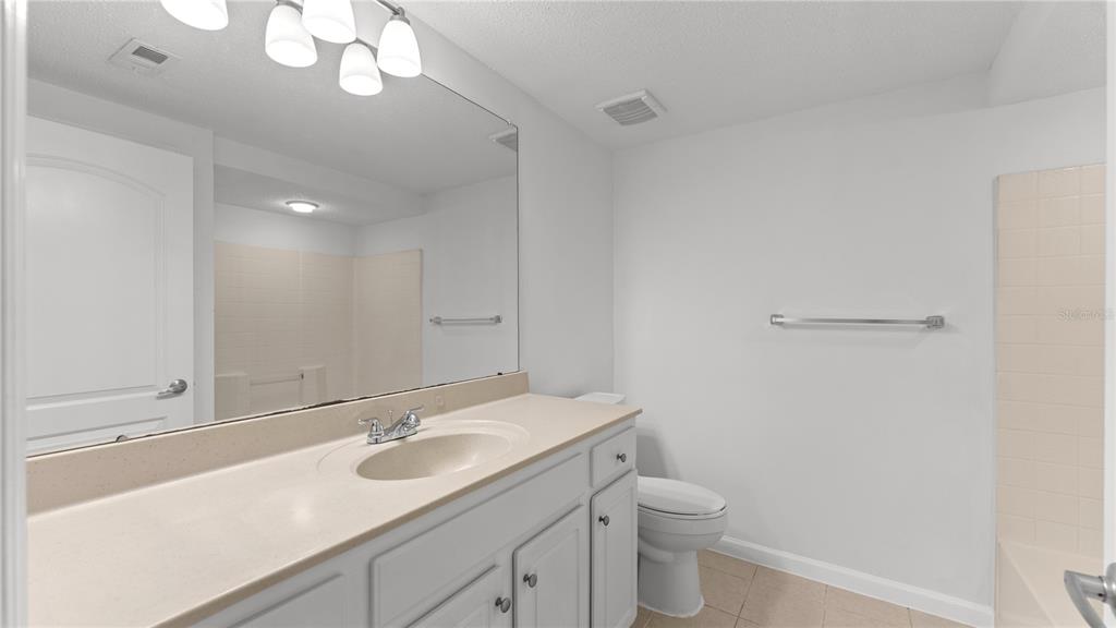 12204 Wild Iris Way, Unit 103 Orlando, FL 32837 - Photo 12 of 22 a bathroom with a sink a toilet and a mirror