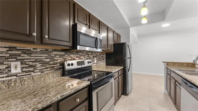 a kitchen with stainless steel appliances granite countertop a stove a sink and a microwave