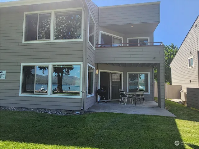 a view of a chair and table in back yard of the house