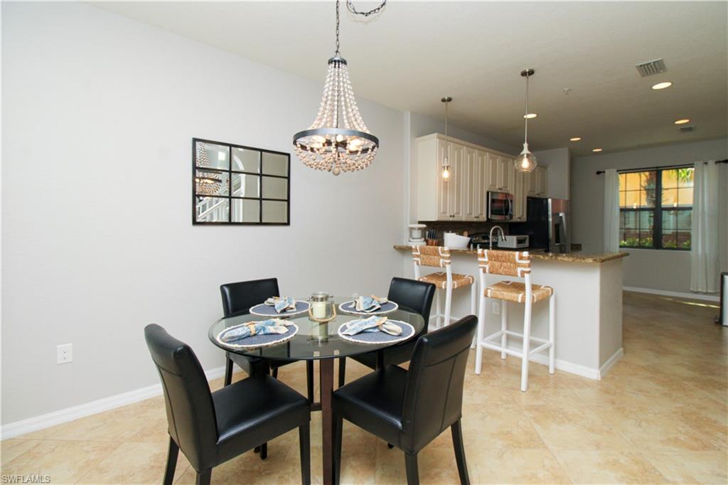 9025 Alturas Street, Unit 3102 Naples, FL 34113 - Photo 14 of 36 a dining room with furniture a chandelier and kitchen view