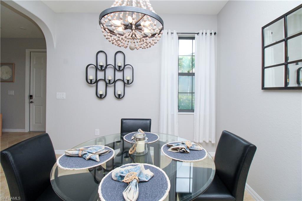 9025 Alturas Street, Unit 3102 Naples, FL 34113 - Photo 17 of 36 a dining room with furniture a potted plant and a chandelier
