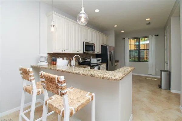 a kitchen with granite countertop sink cabinets and microwave
