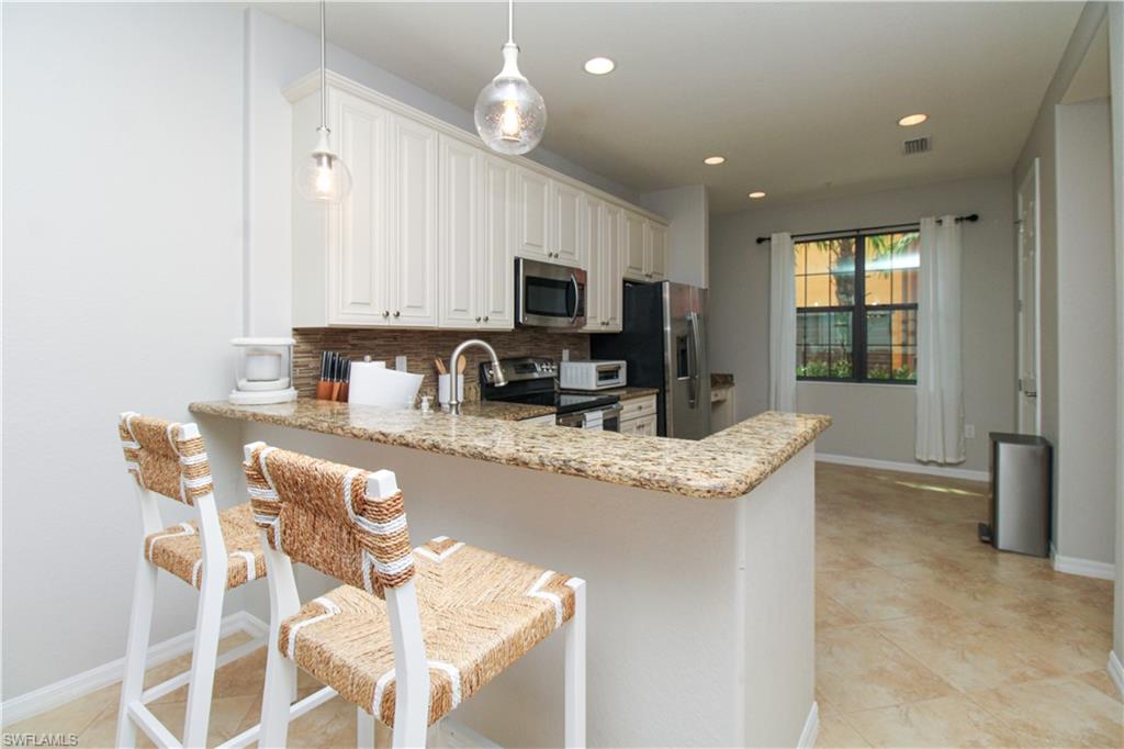 9025 Alturas Street, Unit 3102 Naples, FL 34113 - Photo 18 of 36 a kitchen with granite countertop sink cabinets and microwave