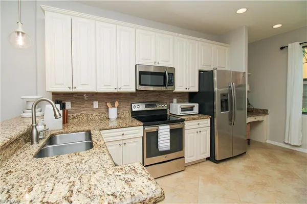 a kitchen with stainless steel appliances granite countertop a stove sink and refrigerator