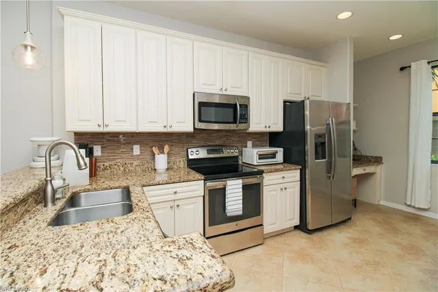 a kitchen with stainless steel appliances granite countertop a stove sink and refrigerator