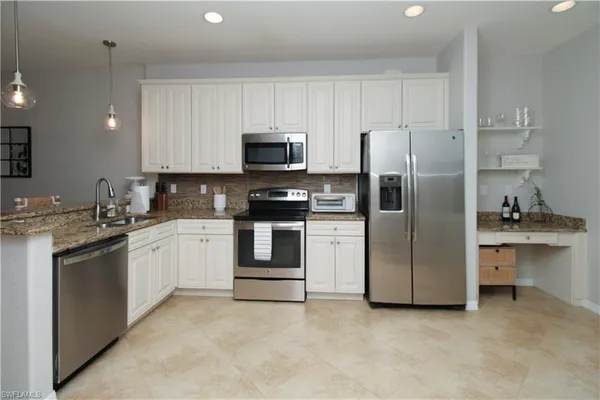 a kitchen with stainless steel appliances and white cabinets