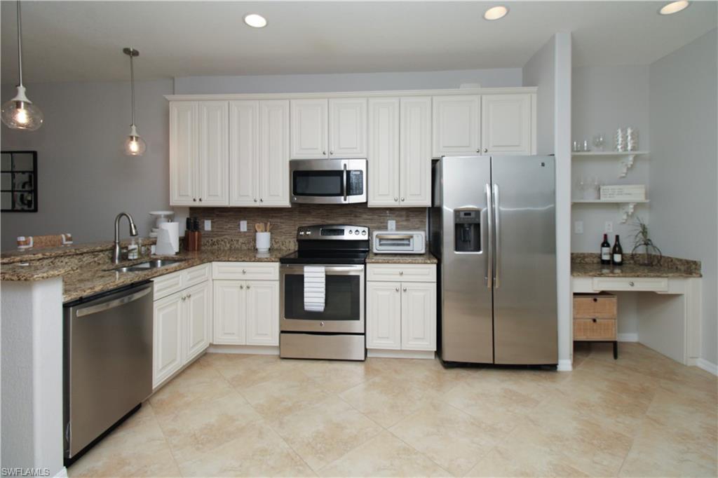 9025 Alturas Street, Unit 3102 Naples, FL 34113 - Photo 20 of 36 a kitchen with stainless steel appliances and white cabinets
