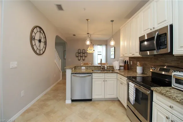 a kitchen with stainless steel appliances granite countertop a stove a sink and a microwave