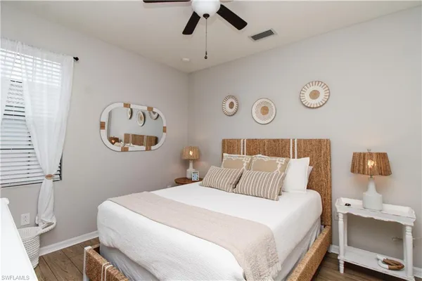 a bedroom with a bed and a lamp on the dresser