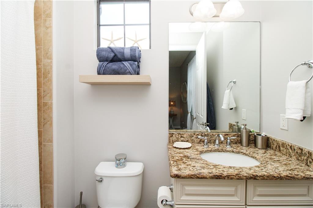 9025 Alturas Street, Unit 3102 Naples, FL 34113 - Photo 30 of 36 a bathroom with a granite countertop sink and a mirror