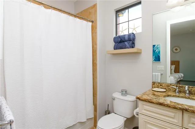 a bathroom with a granite countertop toilet and a sink